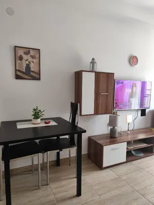 a dining room with a table and a tv at Bili 3 in Paraćin