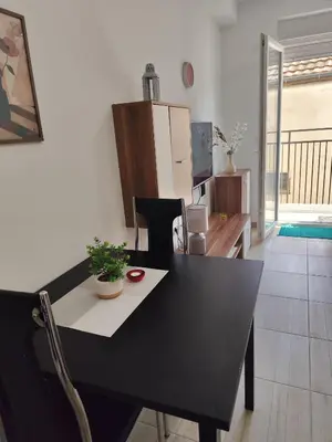 a dining room with a black table and a kitchen at Bili 3 in Paraćin