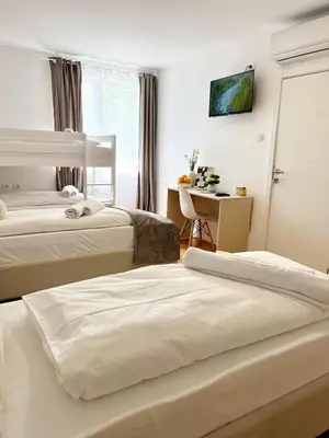 a hotel room with two beds and a desk at Talia in Niš