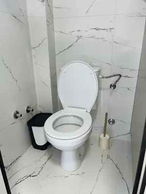 a bathroom with a white toilet and marble walls at Talia in Niš