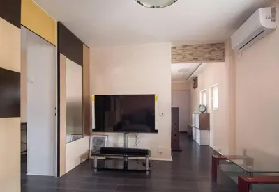 a living room with a large flat screen tv on the wall at The Sunny Peach in Niš