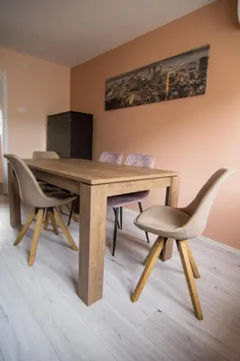 a wooden dining table with two chairs and a television at The Sunny Peach in Niš