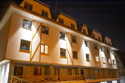 a building with lights on the side of it at Riverside Apartmani Kopaonik in Brzeće