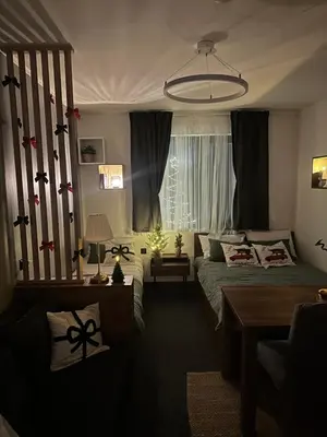 a bedroom with a bed and a table and a window at Riverside Apartmani Kopaonik in Brzeće