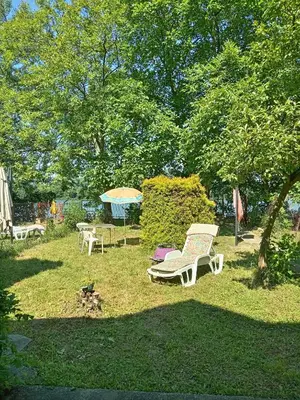 a park with a bench and a table and an umbrella at Ivanka Apartmani in Bukorovac