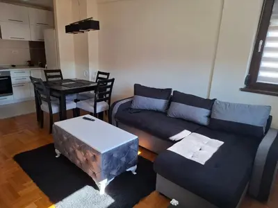 a living room with a couch and a table at Queen delux in Niš