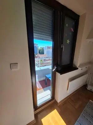 a sliding glass door with a view of a balcony at Queen delux in Niš