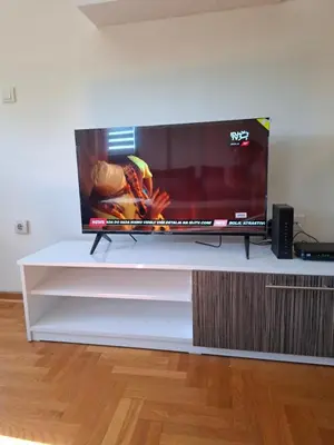 a flat screen tv sitting on a white entertainment center at Queen delux in Niš