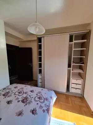 a bedroom with a bed and a closet at Queen delux in Niš