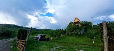 a car parked in a field next to a house at Negovanovic Vikendica in Bukorovac