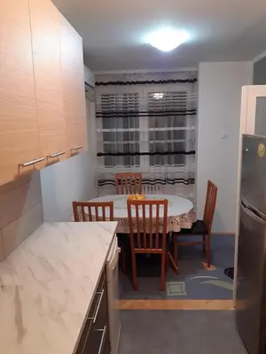 a kitchen with a table and chairs and a refrigerator at M&Z Apartments in Niš