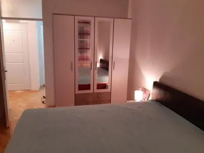 a bedroom with a bed and a closet with a door at M&Z Apartments in Niš