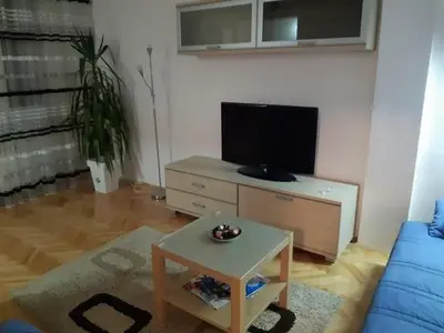 a living room with a blue couch and a table at M&Z Apartments in Niš