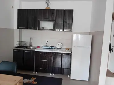 a kitchen with wooden cabinets and a white refrigerator at Suncokret in Kruševac