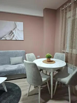 a living room with a table and chairs and a couch at Apartman Dora in Jagodina
