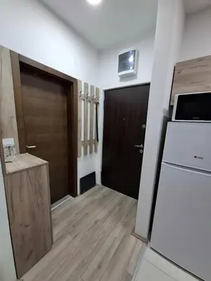 a room with a door and a kitchen with a refrigerator at Apartman Dora in Jagodina