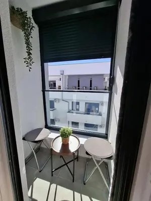 a balcony with a table and two chairs and a window at Apartman Dora in Jagodina