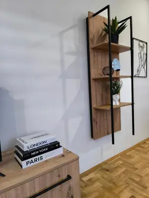 a room with wooden shelves and books on a wall at Apartman Stefani in Pirot