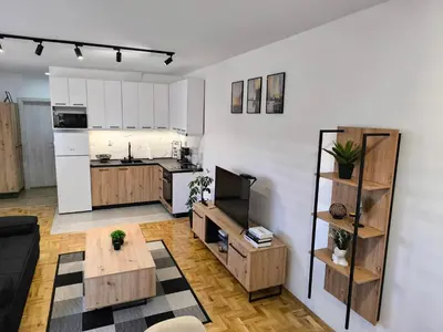 a kitchen with white cabinets and a table in a room at Apartman Stefani in Pirot