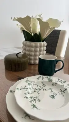 a table with a plate and a cup and a vase at Snowflake A10 in Kopaonik