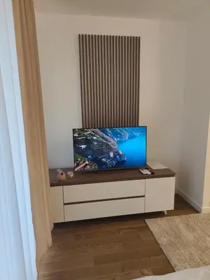 a tv sitting on a dresser in a room at Komitet planet apartments, parking free in Niš