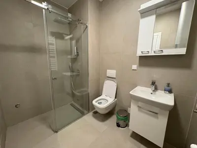 a bathroom with a shower and a toilet and a sink at Komitet planet apartments, parking free in Niš