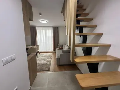a living room with a spiral staircase in a house at Apartman Alibi in Kopaonik