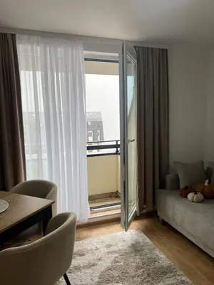 a living room with a couch and a large window at Apartman Alibi in Kopaonik