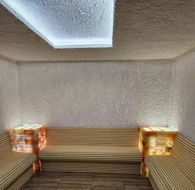 a bench in a room with two wooden tables at Inverno apartman in Kopaonik