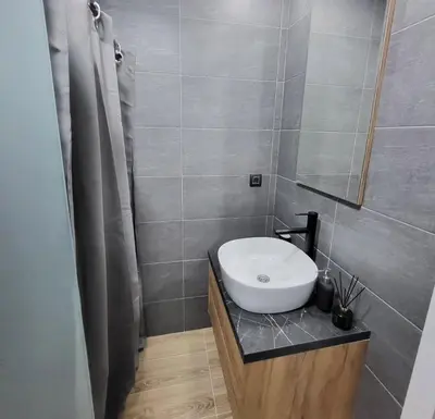 a bathroom with a white sink and a mirror at Inverno apartman in Kopaonik