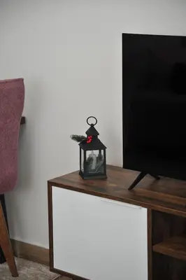 a table with a tv and a small lamp on it at Inverno apartman in Kopaonik