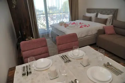 a room with a table and chairs and a bed at Inverno apartman in Kopaonik