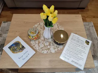 a table with a vase of flowers and a book at Tiha noć II Vrnjačka Banja in Vrnjačka Banja