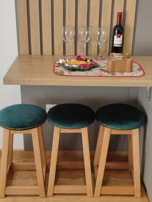 a table with two green chairs and a table with wine glasses at Tiha noć II Vrnjačka Banja in Vrnjačka Banja