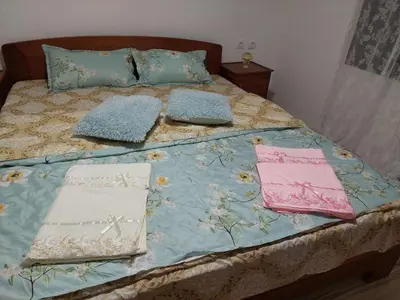 a bed with two towels and pillows on it at South Happiness in Leskovac