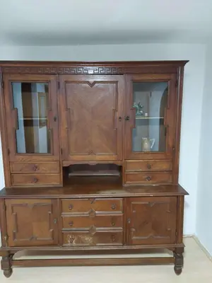 an antique wooden cabinet with glass doors at South Happiness in Leskovac