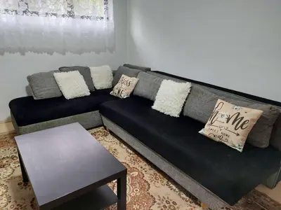 a black couch in a living room with a table at South Happiness in Leskovac