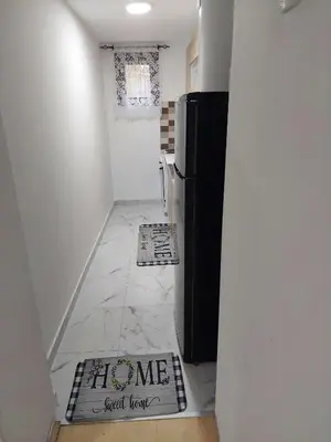a kitchen with a refrigerator and a tile floor at South Happiness in Leskovac