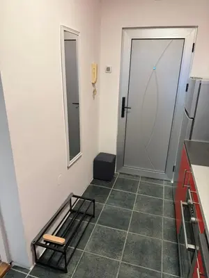 a small kitchen with a door and a tiled floor at Stošić Apartments in Zaječar