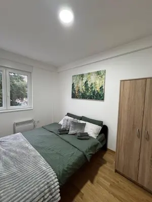 a bedroom with a bed and a wooden cabinet at Apartman Lambros in Soko Banja