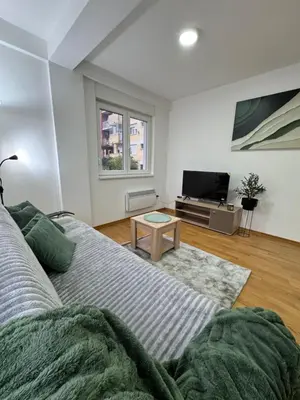 a living room with a couch and a tv at Apartman Lambros in Soko Banja