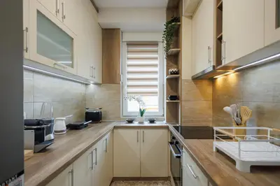 a kitchen with white cabinets and wooden counter tops at M&M apartment in Pirot