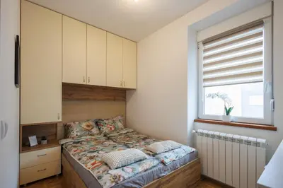 a small bedroom with a bed with a window at M&M apartment in Pirot