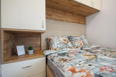 a bedroom with a bed and a dresser at M&M apartment in Pirot
