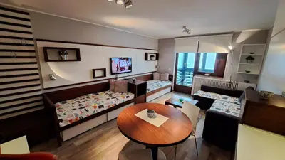 a room with two beds and a table in it at Apartman Bjanka 308 in Kopaonik