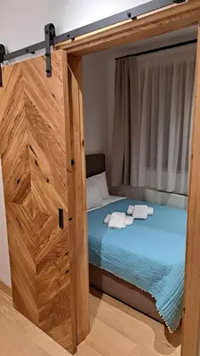 a bedroom with a bed with a wooden frame at Apartmani U CASA DI LEGNO 2,5,8,11 in Kopaonik
