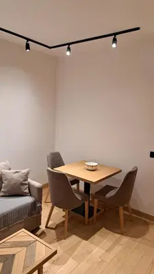 a living room with a table and chairs and a couch at Apartmani U CASA DI LEGNO 2,5,8,11 in Kopaonik