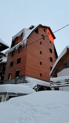 a large building with snow on the roof at Apartmani U CASA DI LEGNO 2,5,8,11 in Kopaonik