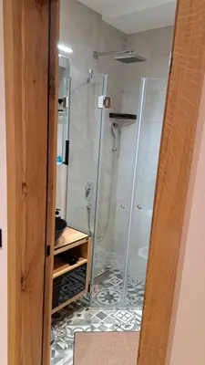 a shower with a glass door in a bathroom at Apartmani U CASA DI LEGNO 2,5,8,11 in Kopaonik