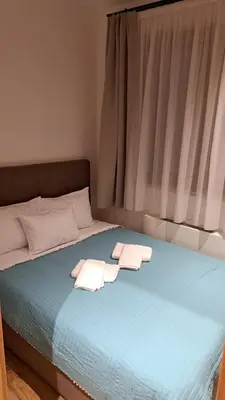 a bed with two towels on it with a window at Apartmani U CASA DI LEGNO 2,5,8,11 in Kopaonik